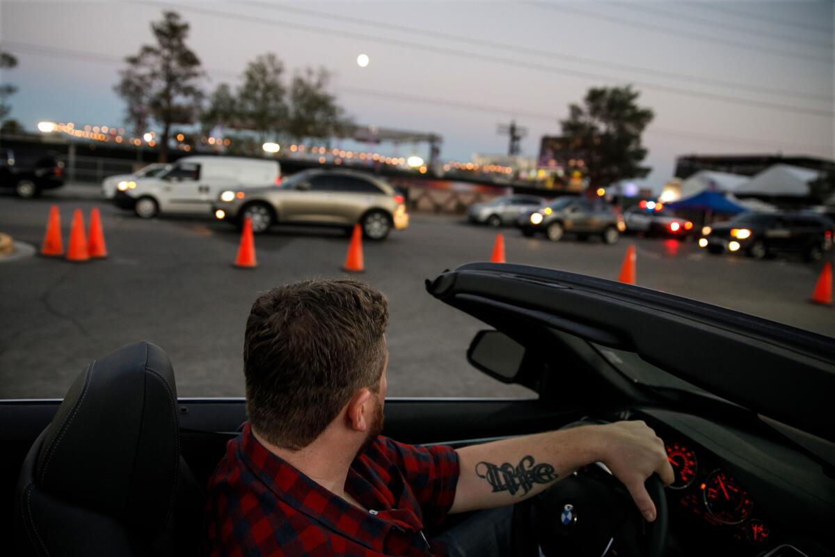 Brian MacKinnon drives the car rented by his friend Adrian Murfitt through Las Vegas after the Strip reopened. (Marcus Yam / Los Angeles Times)