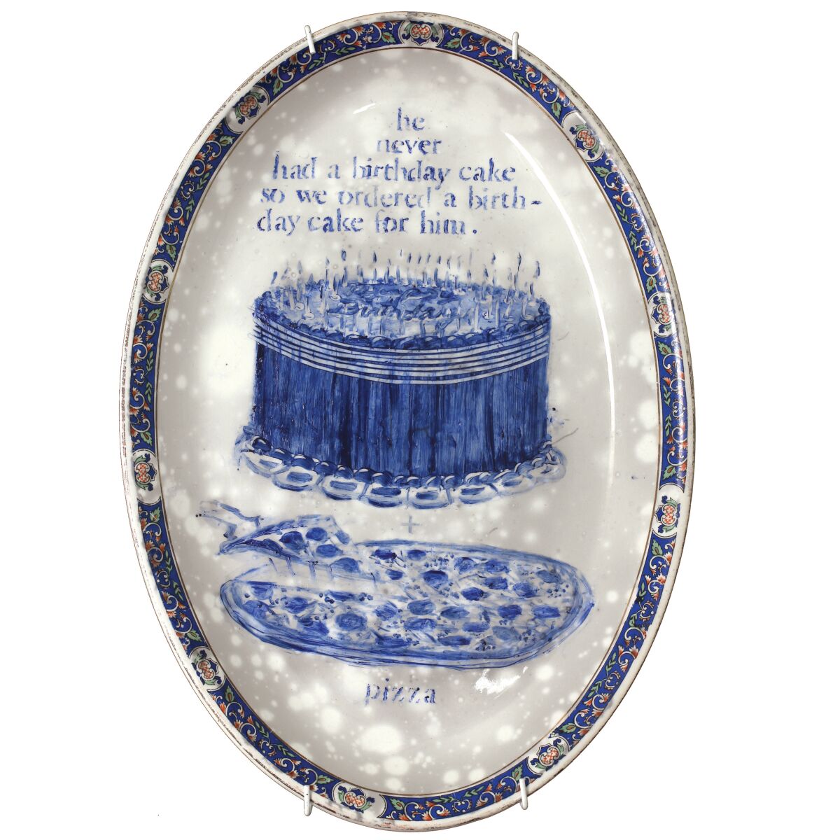 "Indiana 05 May 2007. Pizza and birthday cake shared with 15 family and friends," by Julie Green, 2007, part of "The Last Supper" series on view at the American Museum of Ceramic Art. The platter is 7 inches by 12 inches.