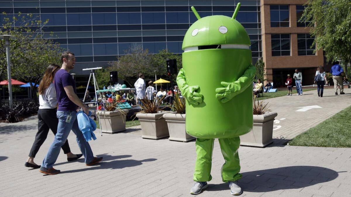 A person dressed as the Android operating system mascot stands at Google's headquarters in Mountain View, Calif., in 2013.