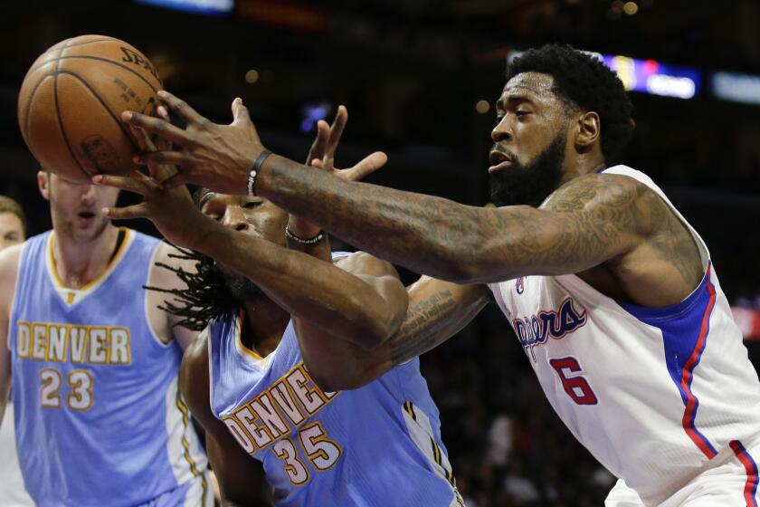 Clippers center DeAndre Jordan battles for a loose ball with Nuggets power forward Kenneth Faried.
