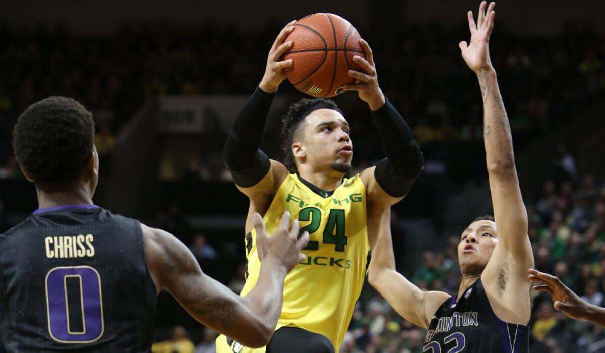 Oregon forward Dillon Brooks (24) drives to the basket between Washington's Marquese Chriss (0) and Dominic Green, right, during the first half.