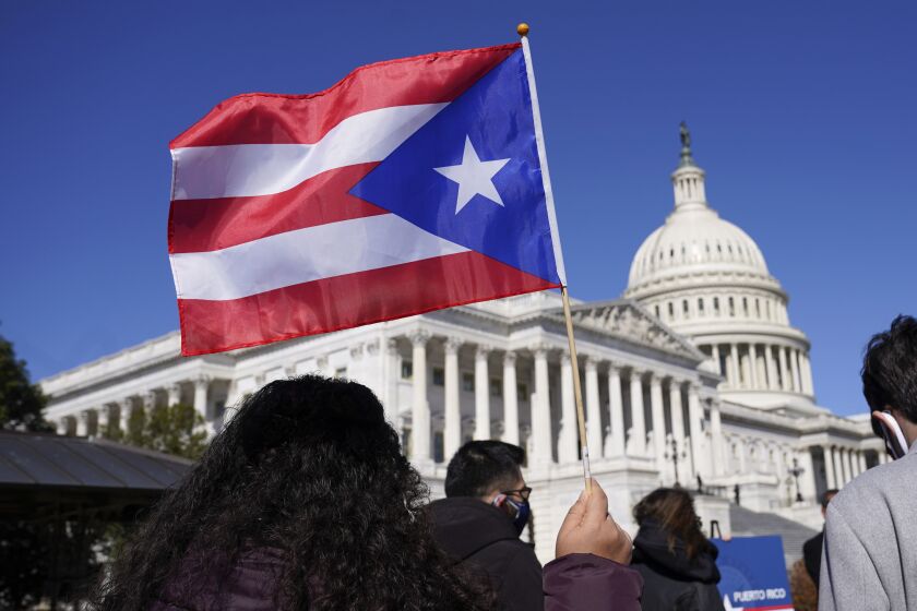 FILE - A woman waves the flag of Puerto Rico during a news conference on Puerto Rican statehood on Capitol Hill in Washington, March 2, 2021. The U.S. House has passed a bill that would allow Puerto Rico to hold the first-ever binding referendum on whether to become a state or gain some sort of independence. It is a last-ditch effort that stands little chance of passing the Senate. (AP Photo/Patrick Semansky, File)