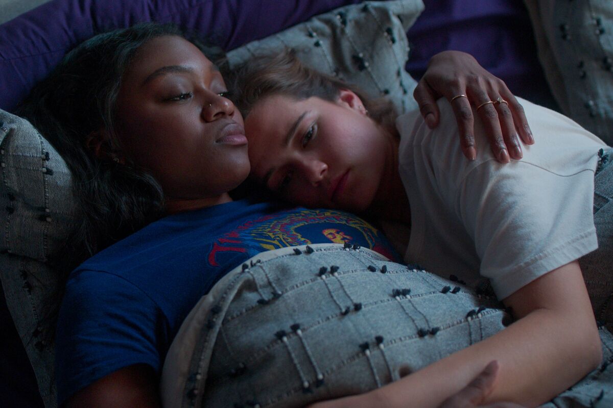 Two girls cuddle in bed