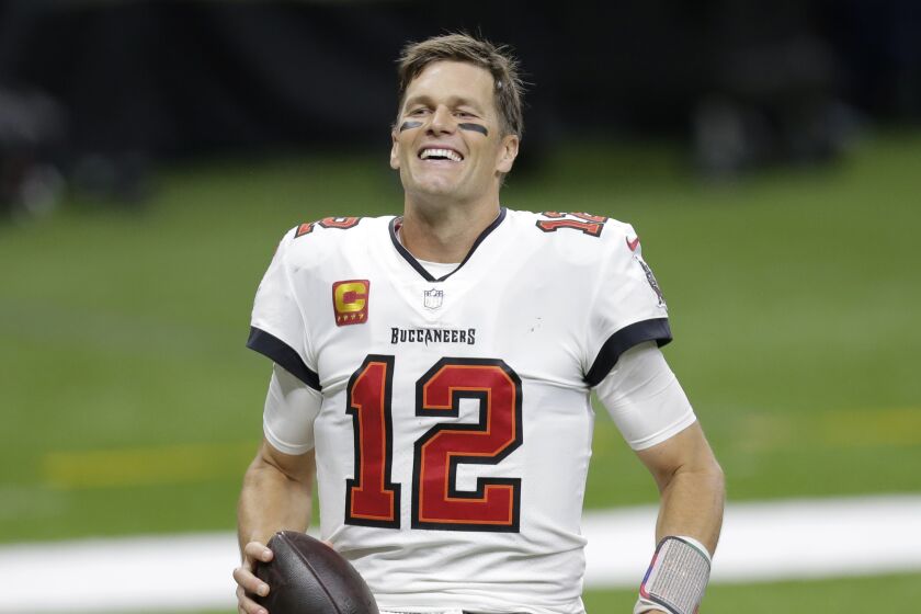 Tampa Bay Buccaneers quarterback Tom Brady smiles after an NFL divisional round playoff football game.