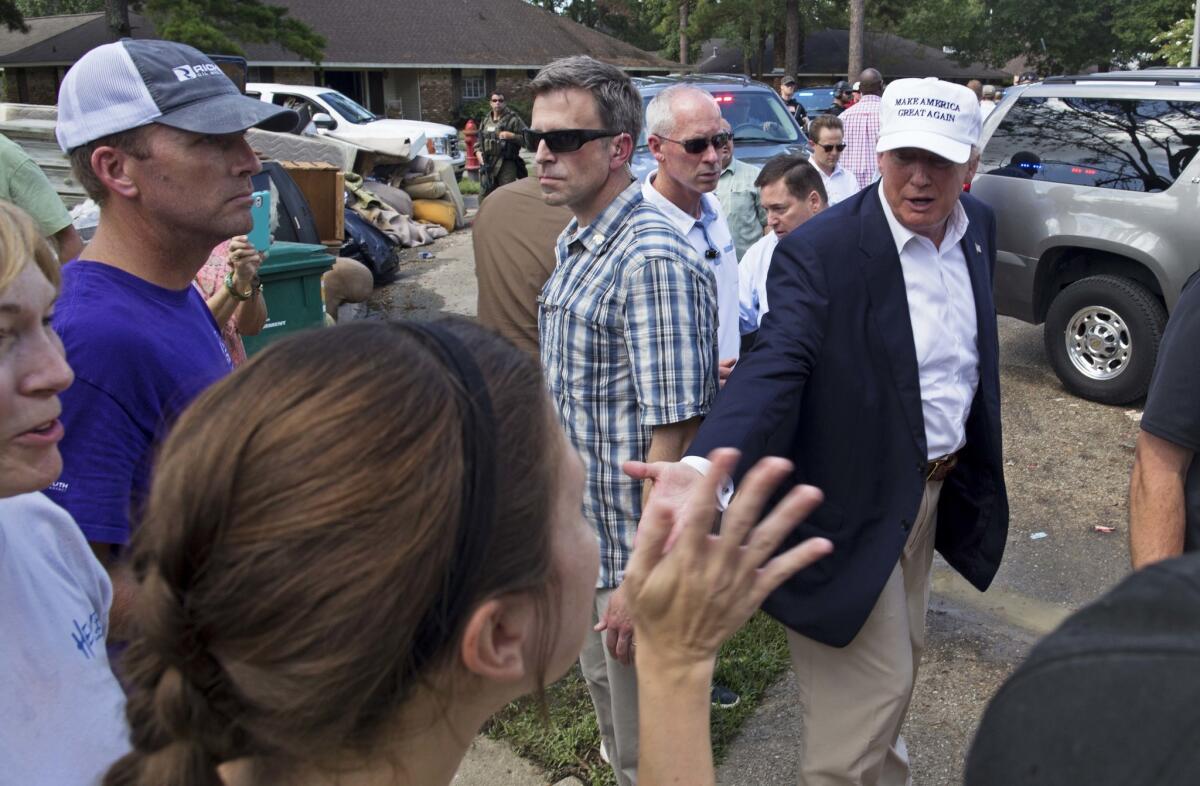 El candidato presidencial republicano Donald Trump saluda a víctimas de las inundaciones durante un recorrido por una zona dañada en Denham Springs, Luisiana, el viernes 19 de agosto de 2016. (AP Foto/Max Becherer)