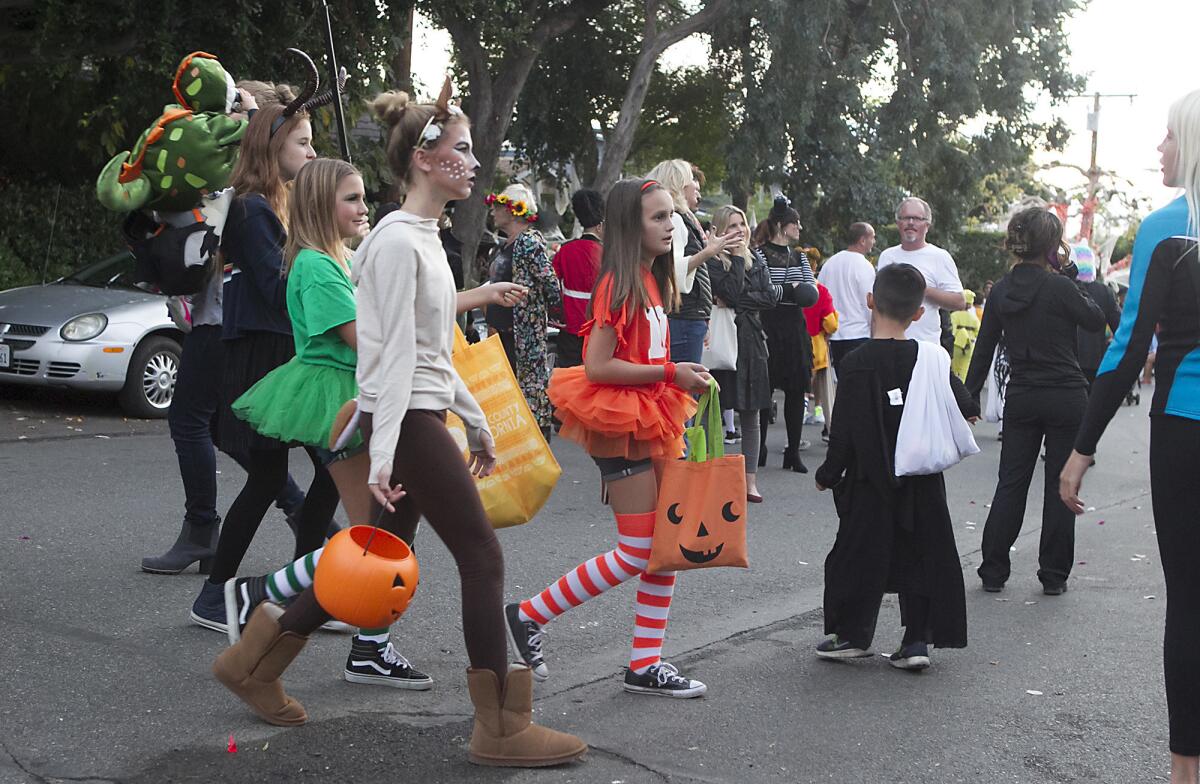 A group of girls in Halloween makeup and tutus joins a crowd at a Laguna Beach Halloween street party.