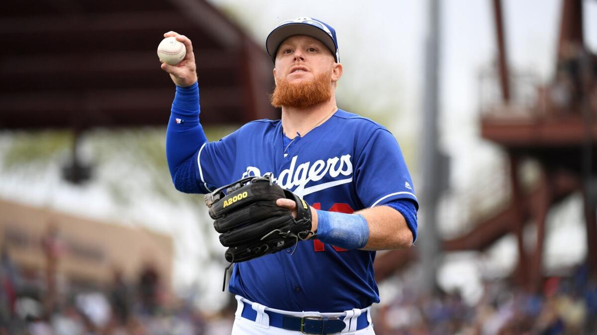 Justin Turner (10) of the Dodgers throws a ball into the stands during a spring training game against the San Francisco Giants at Camelback Ranch on March 11, 2019.