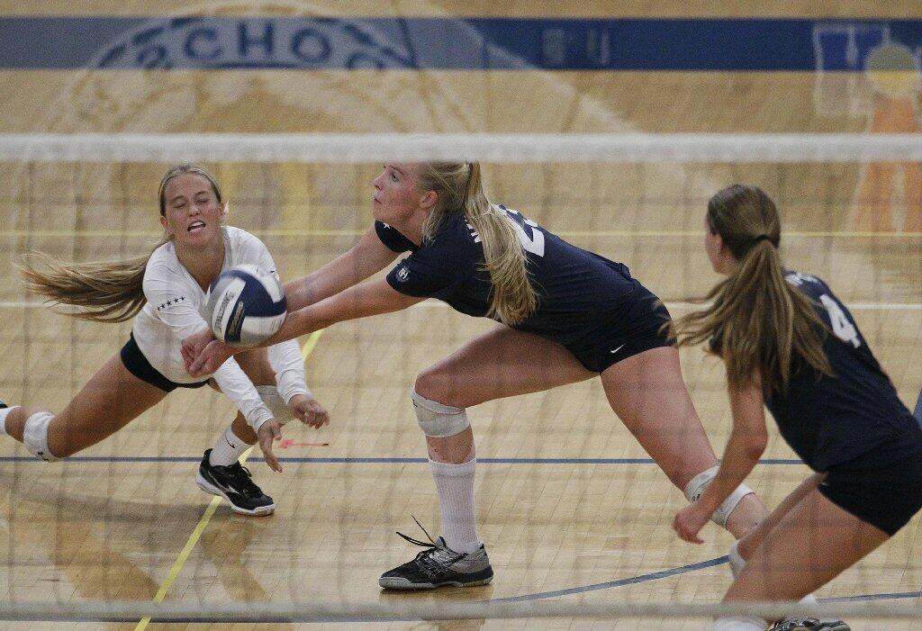 Newport Harbor High's Remy Wilson, left, and Carolyn Bockrath nearly collide while digging a ball during the Battle of the Bay girls' volleyball match on Saturday.