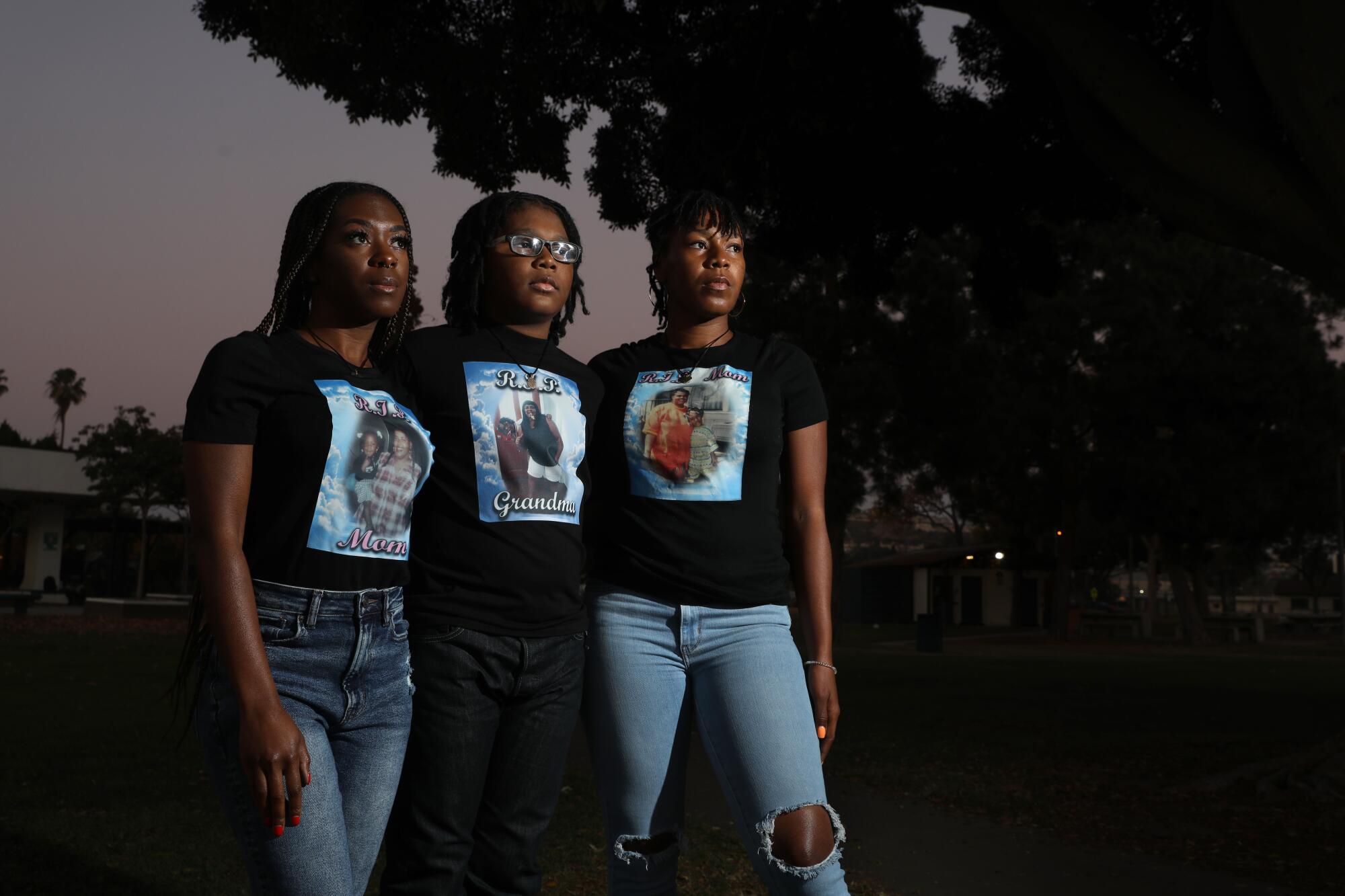 Two women and a boy stand for a portrait wearing T-shirts with images of a slain woman.