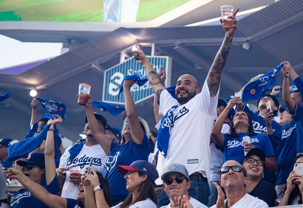 Dodger fans cheer as the Dodgers starting line-up is announced before a game at Dodger Stadium.