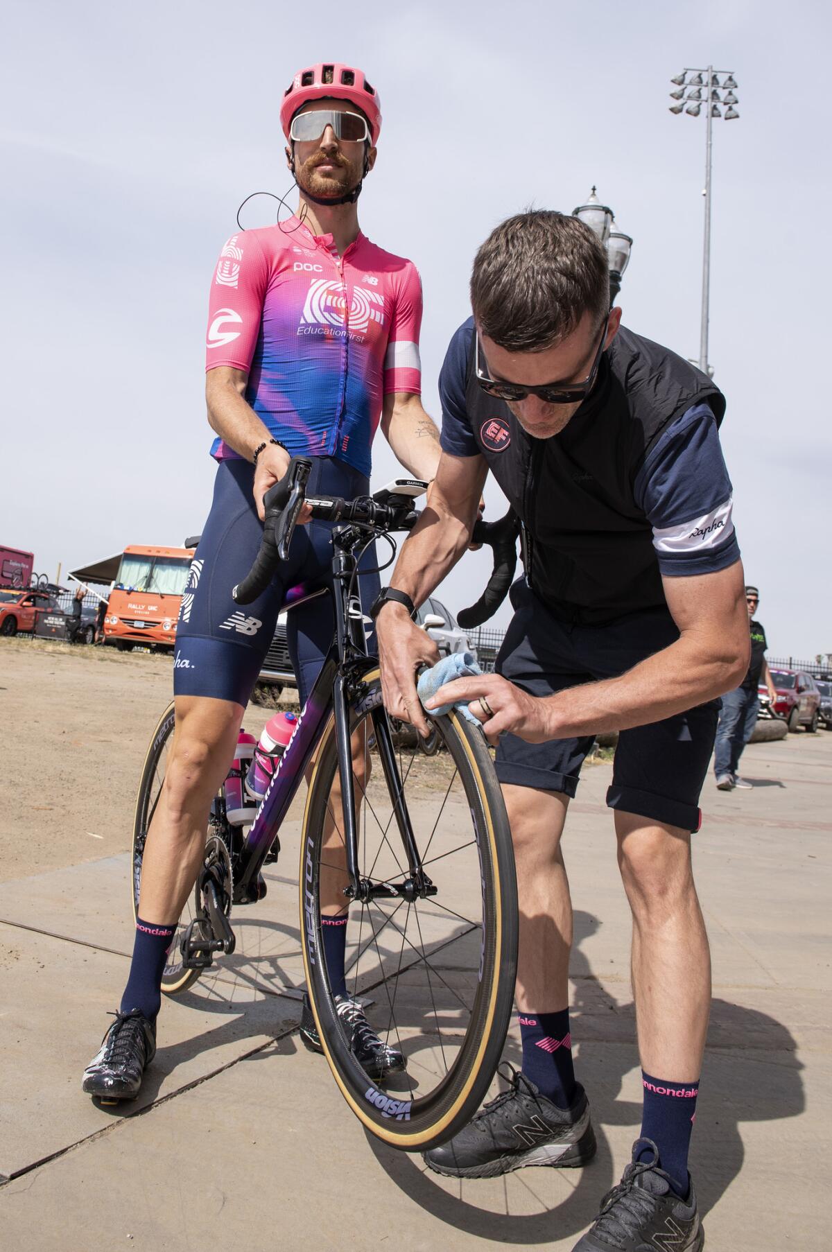 Team mechanic Tom Hopper cleans the tires of Taylor Phinney’s bike to help prevent any punctures after rolling it out of a lot with thistles growing in it.