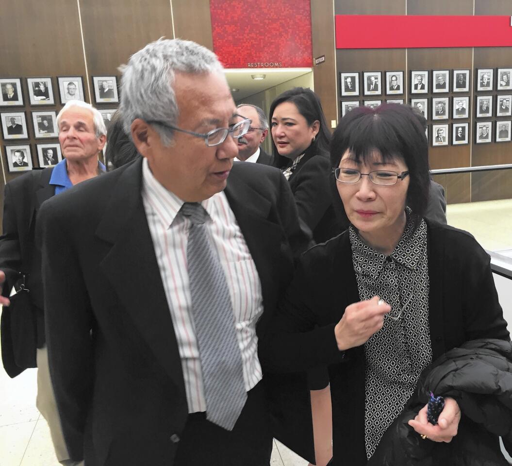 June Kibuishi, attending court this month with her husband, Masa, clasps a ring that her daughter Juri “Julie” Kibuishi wore the night she was killed by Costa Mesa community theater actor Daniel Wozniak in May 2010. Behind them at left is Steve Herr, father of Sam Herr, who also was killed by Wozniak.