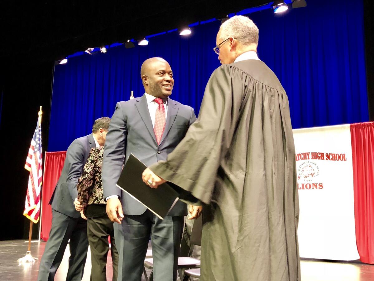 Tony Thurmond shakes hands with retired Alameda County Superior Court Judge Gordon Baranco after taking the oath of office.