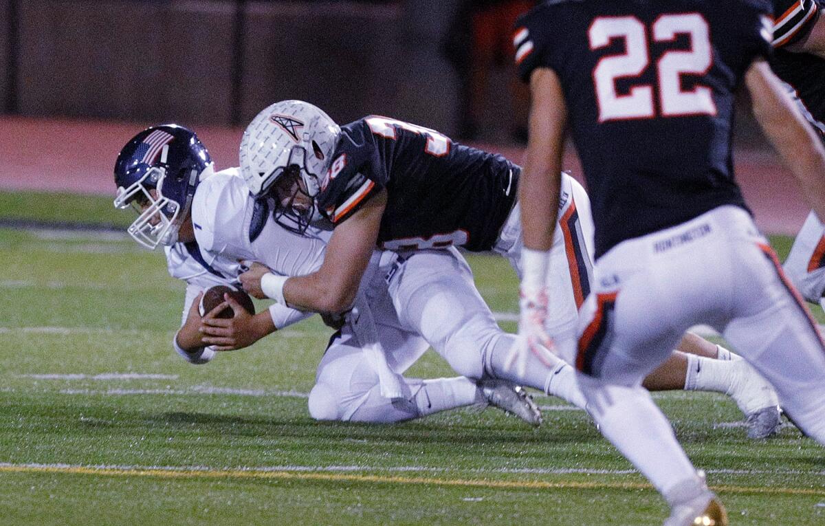 Huntington Beach's Brandon Bova sacks Newport Harbor's Nick Kim in a Sunset League game on Oct. 11 at Cap Sheue Field.