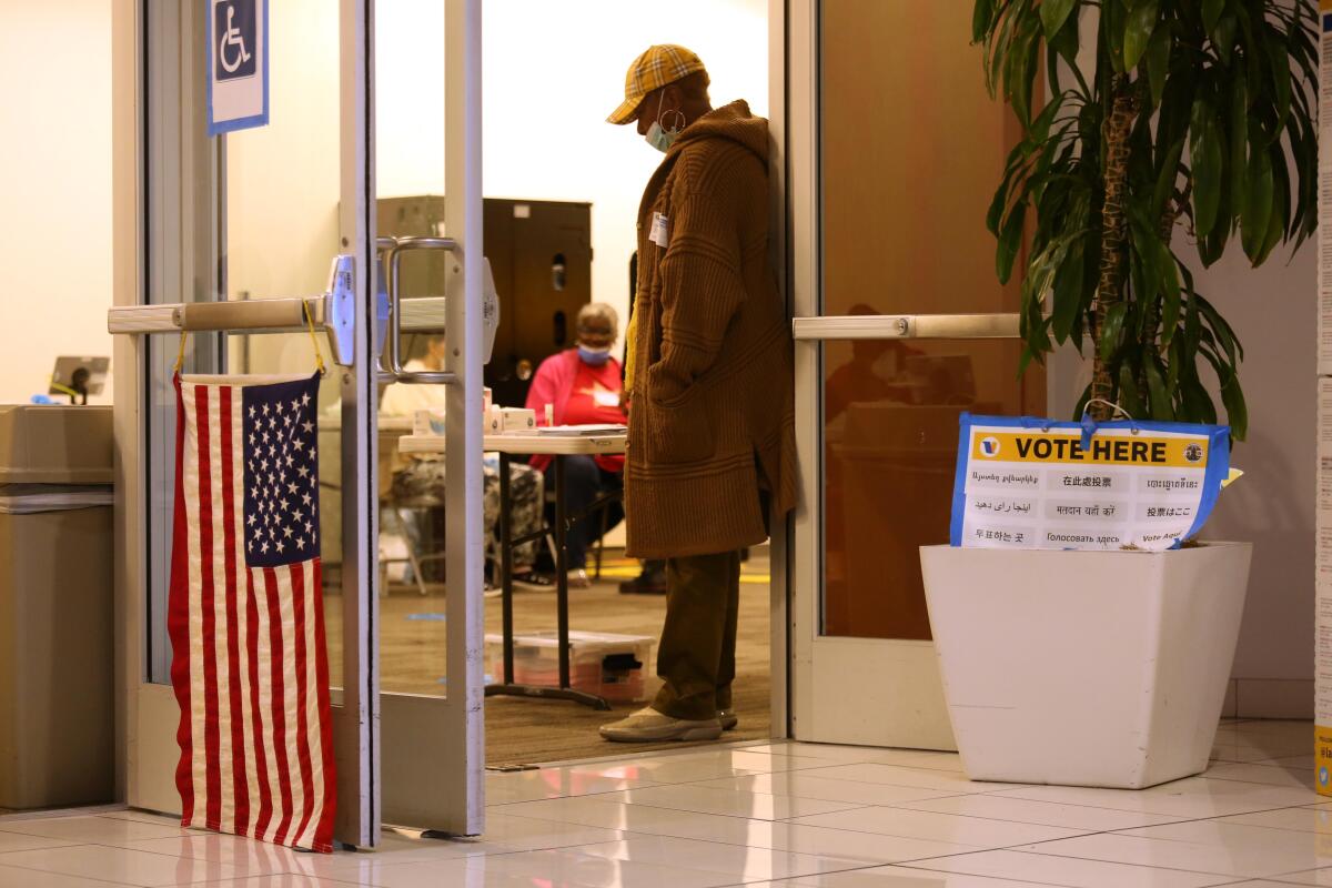 An election worker waits at the door of a polling center