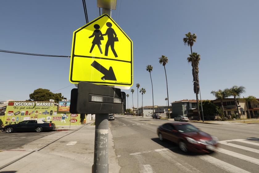 LOS ANGELES, CA - APRIL 17, 2019 - New crosswalk at 94th and Figueroa as L.A. struggles to reduce fatal traffic crashes on city streets. The city has added new infrastructure -- more visible crosswalks, flashing lights at crosswalks, digital signs that show drivers their speed -- to help protect pedestrians and bicyclists. (Al Seib / Los Angeles Times)