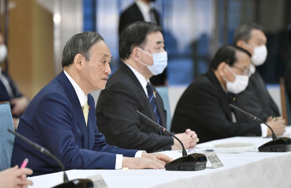 Japanese Prime Minister Yoshihide Suga, left, at a Cabinet meeting