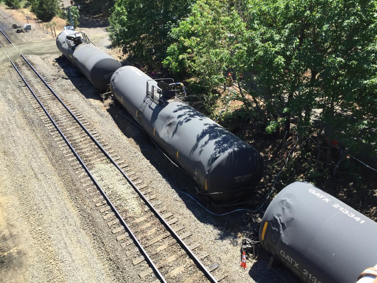 Crumpled oil tankers lie beside railroad tracks days after a fiery derailment in the Columbia River Gorge about 70 miles east of Portland, Ore.
