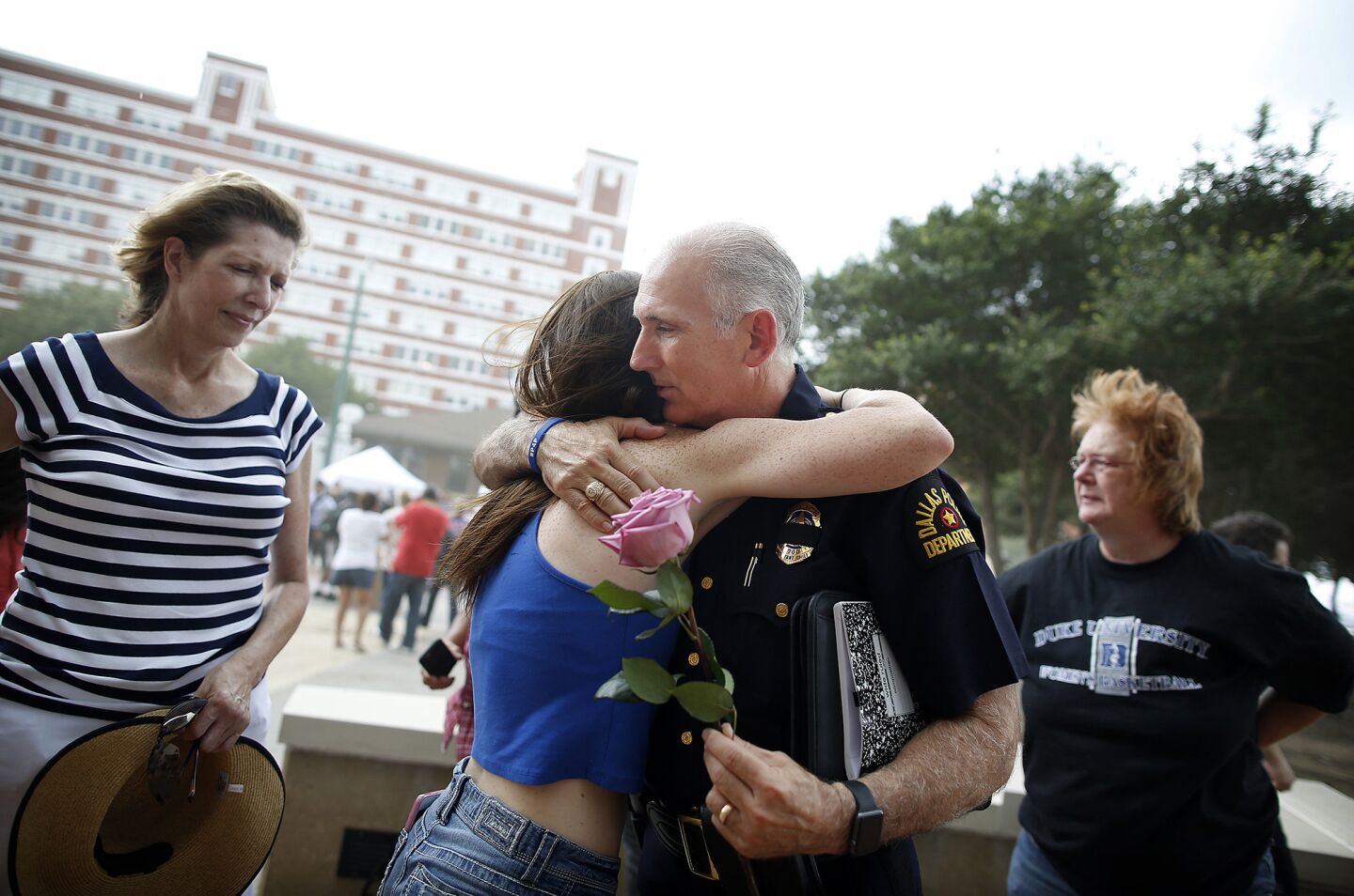 Assistant Police Chief, Gary Tittle, gets a hug at the Dallas Police Headquarters.