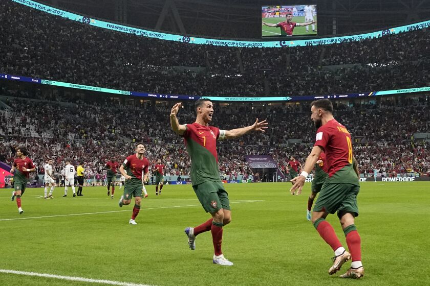Portugal's Cristiano Ronaldo, centre, celebrates after scoring his side's opening goal during the World Cup group H soccer match between Portugal and Uruguay, at the Lusail Stadium in Lusail, Qatar, Monday, Nov. 28, 2022. (AP Photo/Themba Hadebe)
