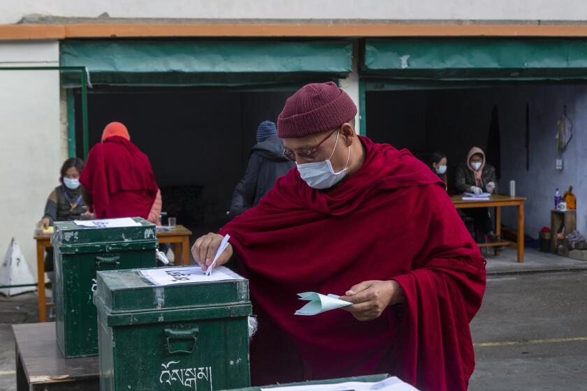 A Tibetan Buddhist monk casts his ballot in Dharmsala, India, on Sunday.