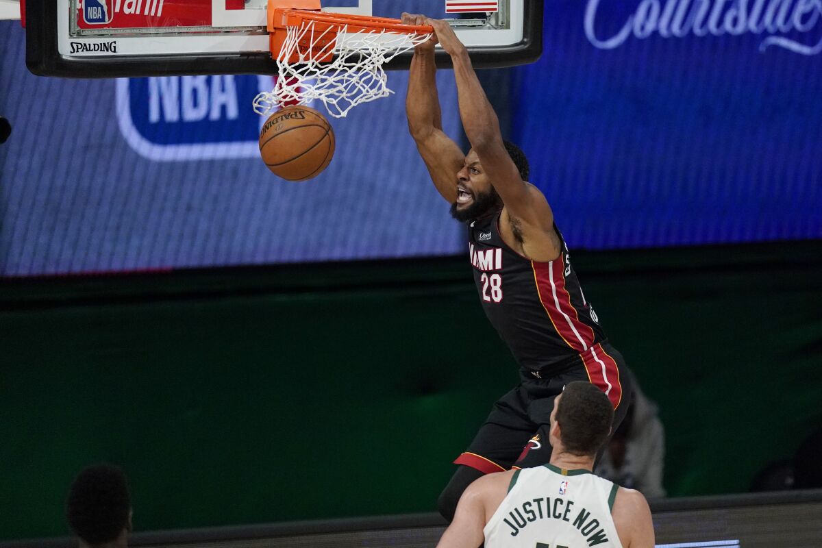 Miami Heat's Andre Iguodala (28) dunks in front of Milwaukee Bucks' Brook Lopez (11) in the second half of an NBA conference semifinal playoff basketball game Tuesday, Sept. 8, 2020 in Lake Buena Vista, Fla. (AP Photo/Mark J. Terrill)