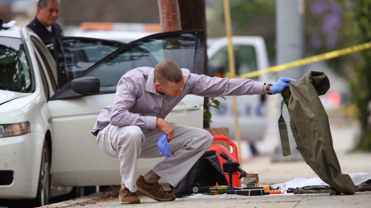 Authorities investigate the scene along 11th Street in Santa Monica, where a car was found with weapons, ammunition and other suspicious items.