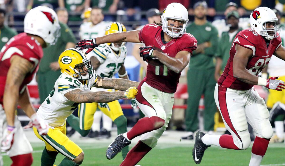 Arizona Cardinals' Larry Fitzgerald (11) breaks away from Green Bay Packers' Morgan Burnett for a 75-yard pass reception to set up the winning touchdown during their NFL Playoff Game Saturday night.