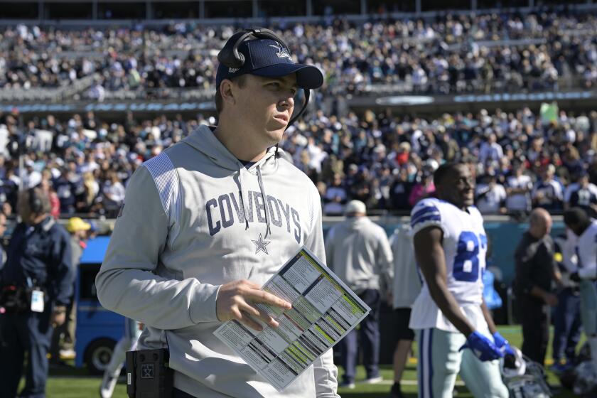 Dallas Cowboys offensive coordinator Kellen Moore stands on the sideline.