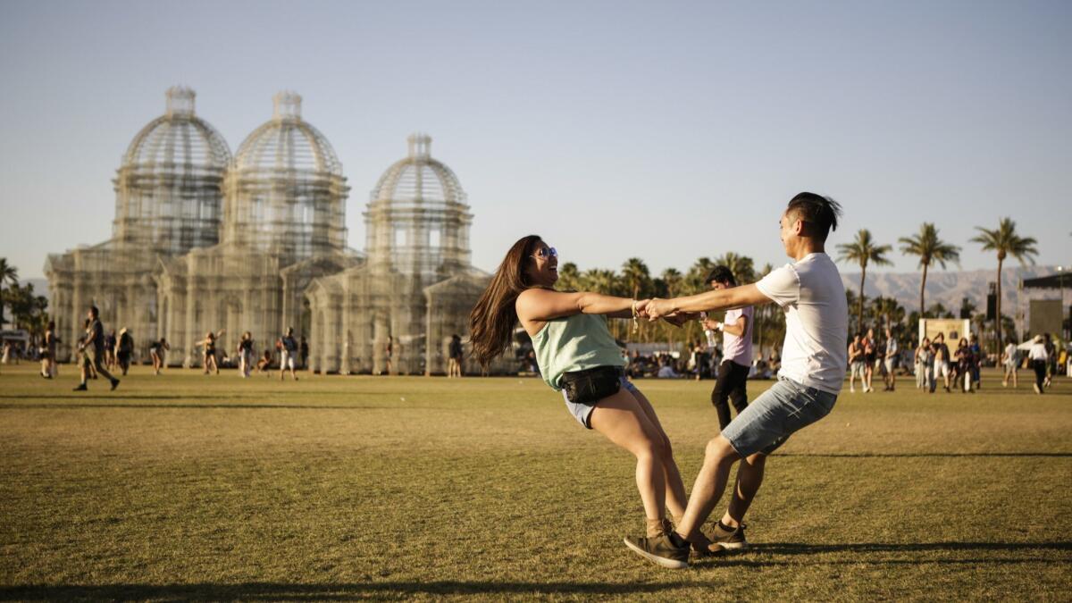 Jacqueline Le from Santa Ana is held by her boyfriend, Bunsomitt Nhoung from Garden Grove as they dance together Sunday at Coachella during weekend two.