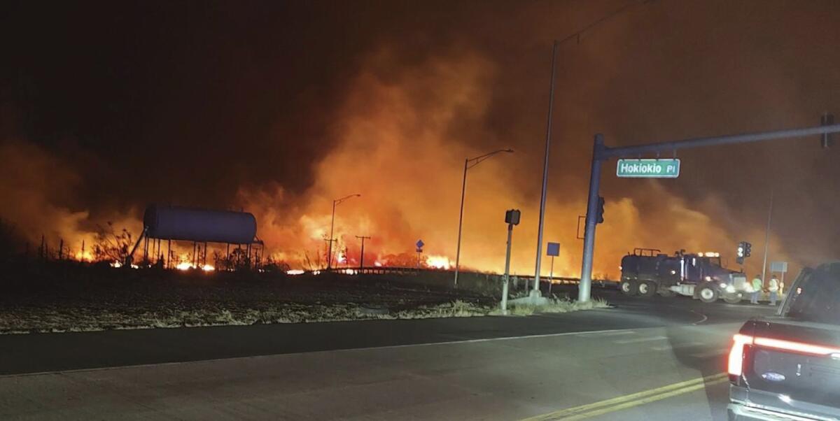 La foto distribuida por el condado de Maui muestra llamas y humo en la intersección 