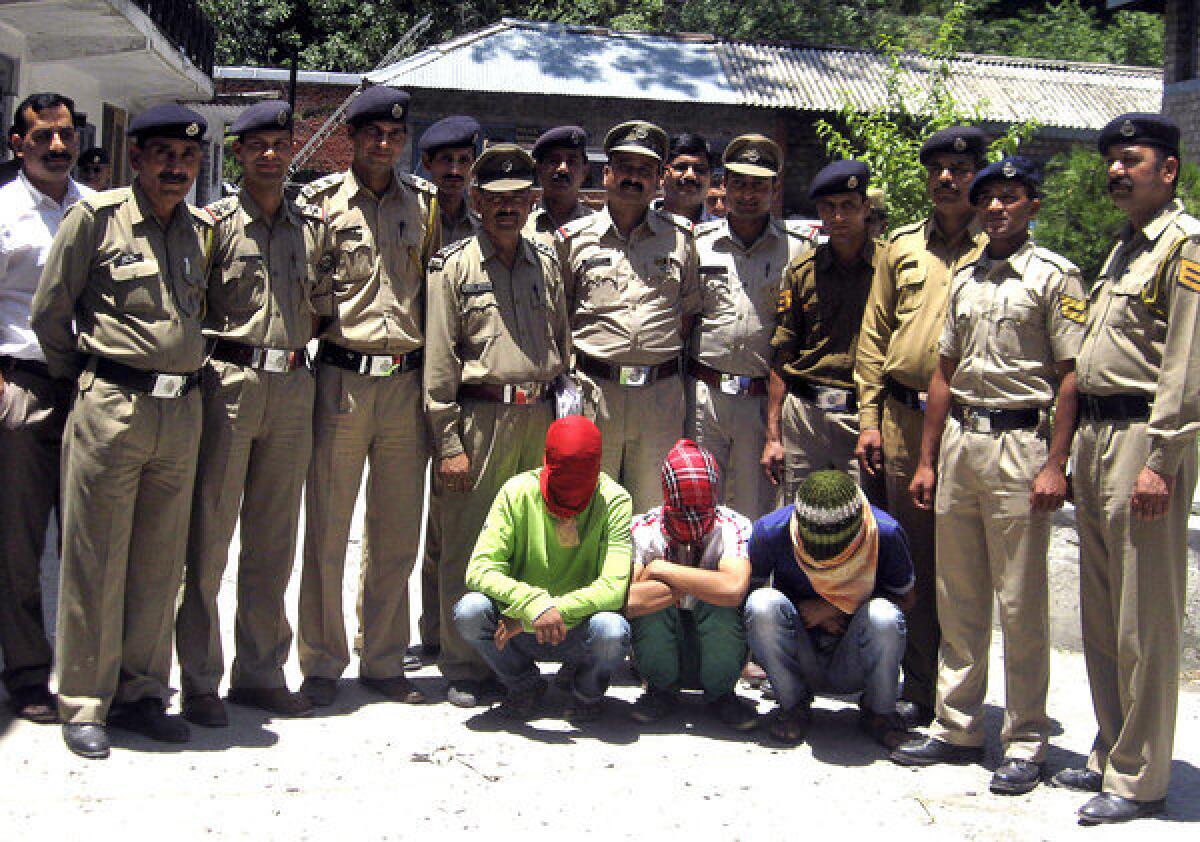 Indian police stand with three hooded men suspected in the gang-rape of an American woman in Manali this month.