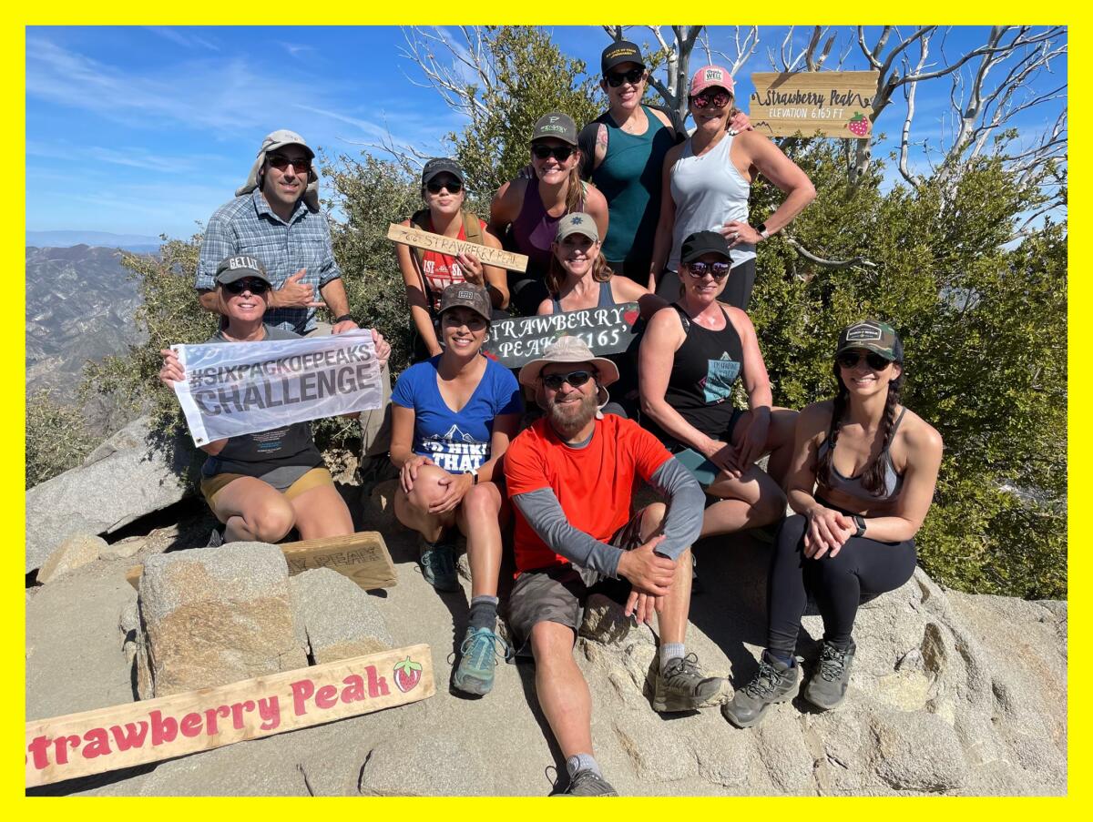 A group of 11 folks sit atop the rocks at Strawberry Peak. 