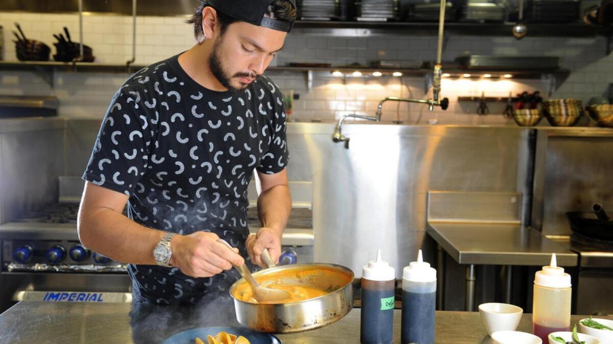Louis Tikaram, the young chef at E.P. & L.P., makes turmeric and coconut curry with clams and sea beans.