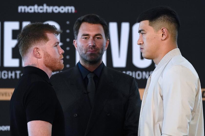 ARCHIVO - Saúl "Canelo" Álvarez (izquierda) posa junto a Dmitry Bivol, con el promotor Eddie Hern en el medio, en San Diego, wel 2 de marzo de 2022. Álvarez y Bivol pelearán por el título mundial en Las Vegas, el 7 de mayo. (AP Foto/Gregory Bull)