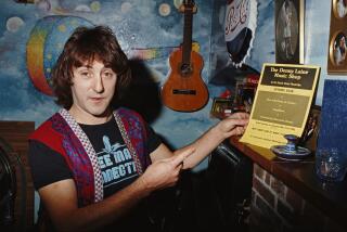 English singer-songwriter, and former Wings and Moody Blues guitarist, Denny Laine shows his memorabilia, including a leaflet of 'The Denny Laine Music Shop' opening, Weybridge, 1981. (Photo by Michael Putland/Getty Images)