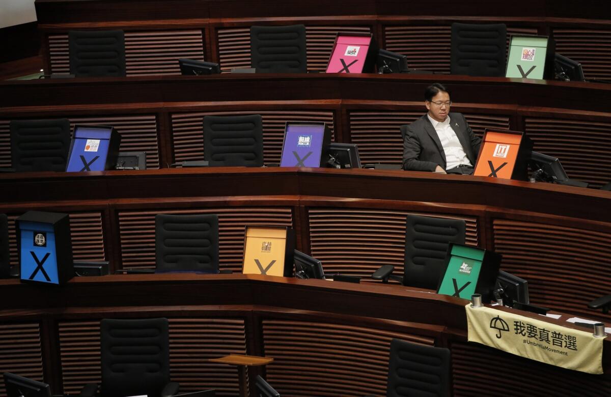 Pro-democracy lawmaker Charles Mok listens to the Hong Kong legislature debate election proposals next to placards symbolizing a vote against the government's controversial roadmap.