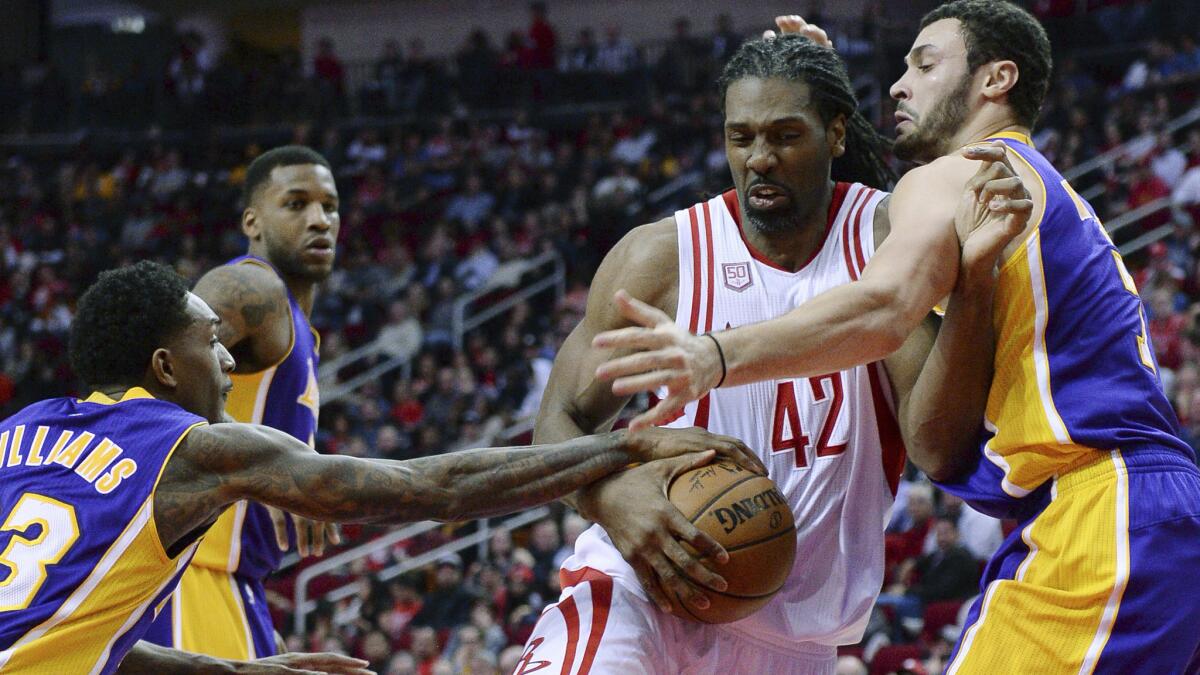 Rockets center Nene (42) tries to drive between Lakers guard Lou Williams (23) and Larry Nance Jr. during a game earlier this season.