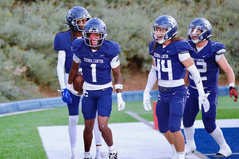 Sierra Canyon defensive back Jae'on Young (left) celebrates his interception return for a touchdown in the first quarter against Oaks Christian on August 30, 2024.