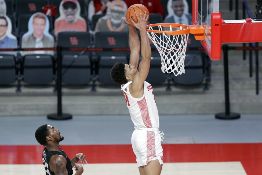 Houston guard Quentin Grimes, right, dunks as Central Florida guard Dre Fuller Jr., left, looks on during the first half of an NCAA college basketball game Sunday, Jan. 17, 2021, in Houston. (AP Photo/Michael Wyke)