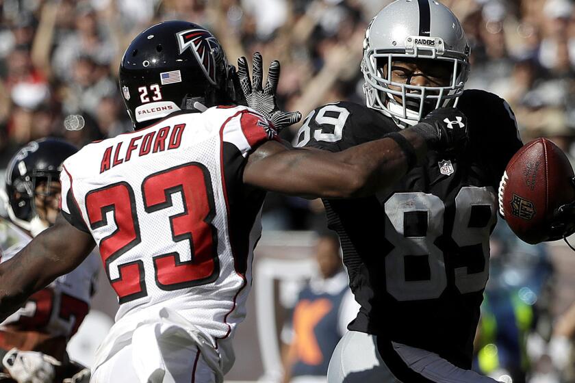 Raiders receiver Amari Cooper tries to evade Falcons cornerback Robert Alford after a reception in the second half Sunday.