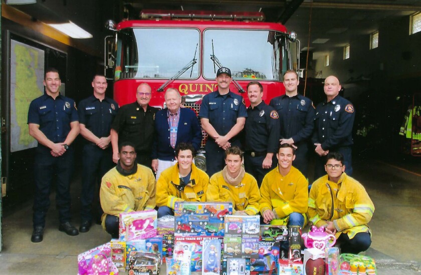 Jim Hughes, fourth from left, Grand Knight representing the La Crescenta-Montrose Knights of Columbus membership, delivers new toys to L.A. County Fire Station #82 in La Canada Flintridge for their Toy.