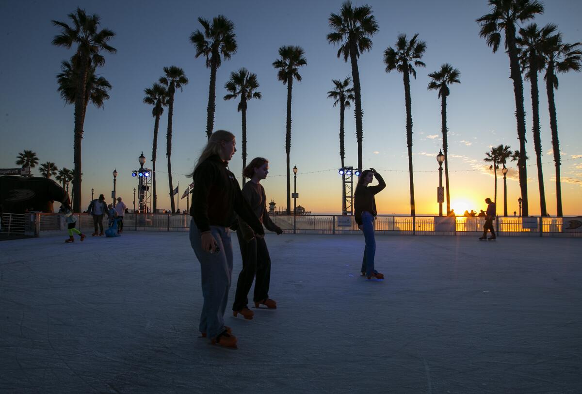 Guests skate the ice at the Surf City Winter Wonderland at the Huntington Beach Pier Plaza on Friday.