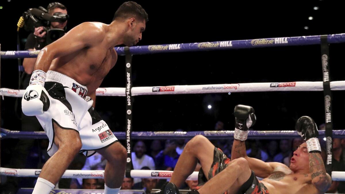 Amir Khan, left, knocks down Samuel Vargas in action during their Welterweight contest at Arena Birmingham, in Birmingham, England, Saturday Sept. 8, 2018. (Nick Potts/PA via AP)