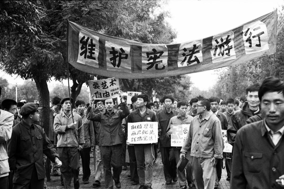 Protesters march carrying signs in the documentary “Beijing Spring.”