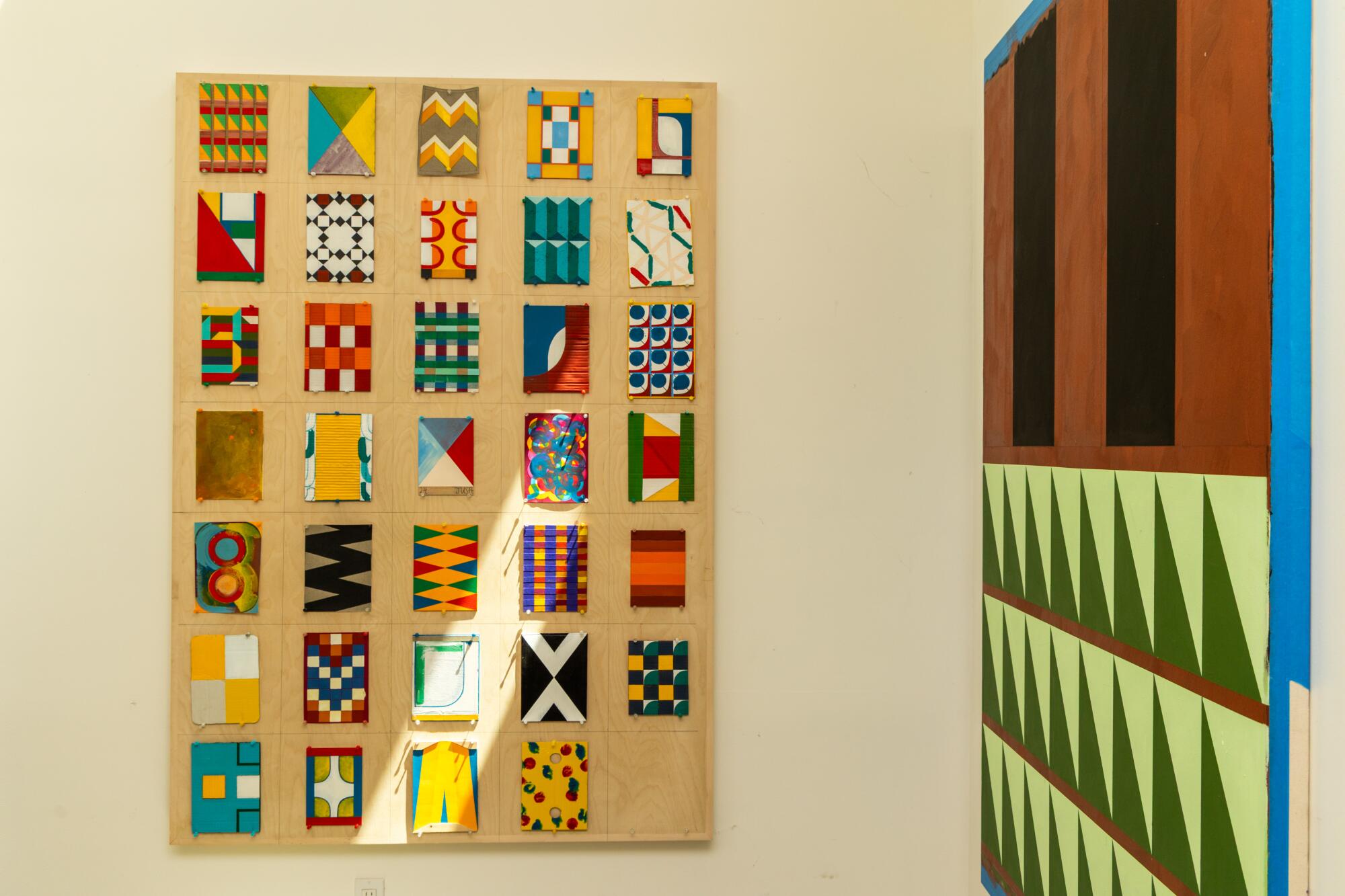 Geometrically painted canvases hang in ADU.