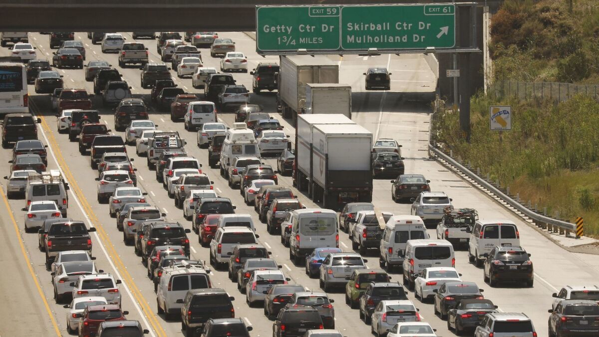 Traffic creeps through the Sepulveda Pass on the 405 Freeway, a route on which transportation officials will consider charging drivers more. On Thursday, Metro officials also gave the green light to studying a new tax on Uber and Lyft rides.