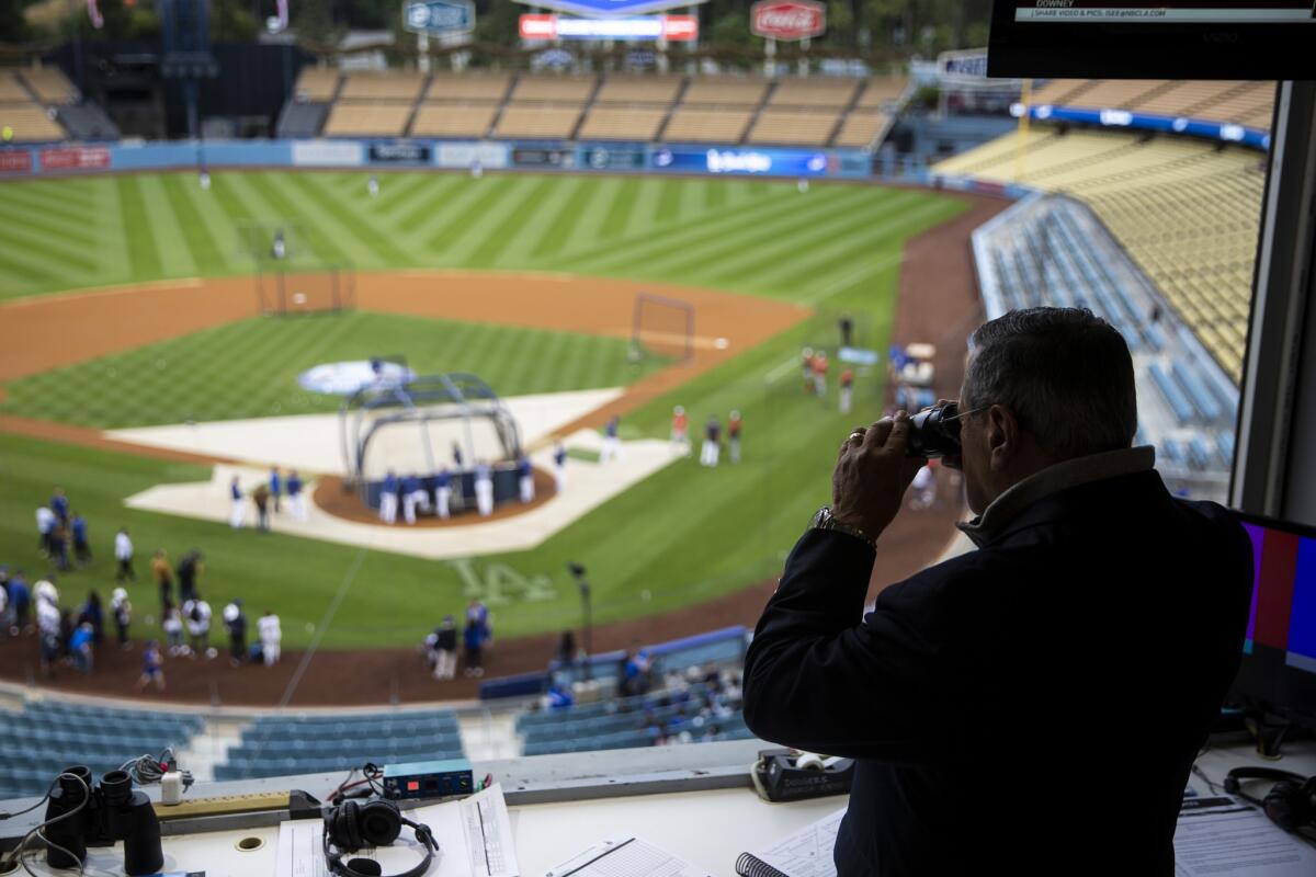 Jaime Jarrin scans the field before a Dodgers game against the Nationals earlier this season.