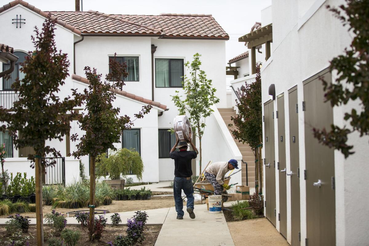 Workers put the finishing touches on the Vernon Village Park Apartments. The 45-unit complex will double the population of the five-square mile city, located five miles south of downtown Los Angeles.