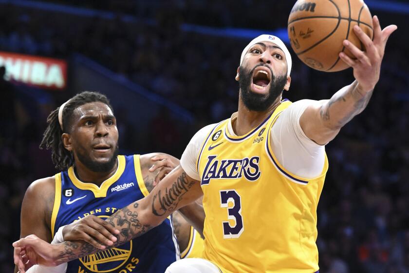 Los Angeles, CA - May 12: Los Angeles Lakers forward Anthony Davis, right, stretches to grab a rebound against Golden State Warriors forward Kevon Looney during the first half of the NBA Playoffs Western Conference semifinals at Crypto.com Arena on Friday, May 12, 2023 in Los Angeles, CA.(Wally Skalij / Los Angeles Times)